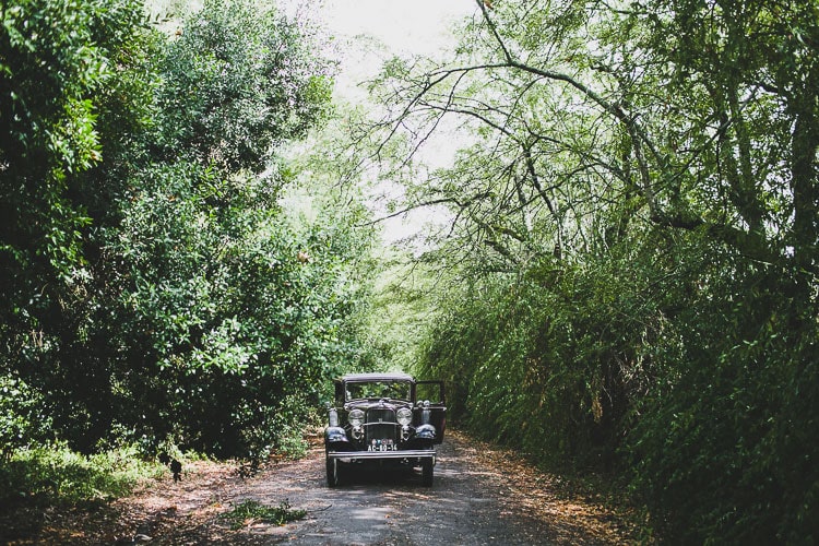 photography of a bride and groom in forest in portugal vintage old car ford for a wedding small elopment classic vintage ford 1933 for wedding in portugal