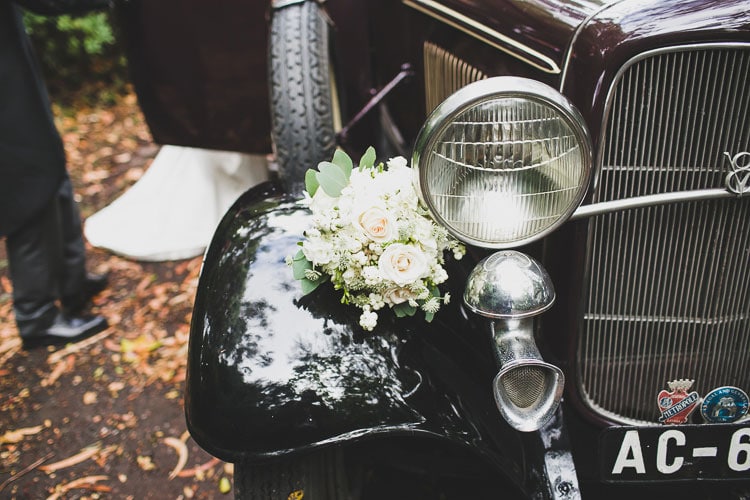 bride and groom couple in love in front of a old vintage ford car for weddings in Lisbon portugal by jesus caballero photography classic vintage ford 1933 for wedding in portugal