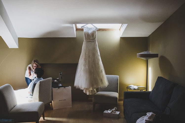 A gown during the getting ready of a bride in a destination wedding in Spain. Charming Vintage Spanish Wedding caceres, jesus caballero photographer rustic wedding at a castle #castle #destination #spain #vintage #junebug #irish #londoners #ireland #uk #rosaclara #gown #whitedress
