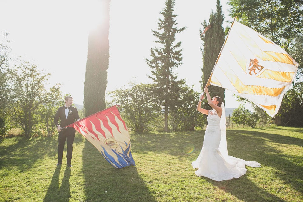 bride and groom with Flag wavers from Saracen Joust tuscany arezzo asciano