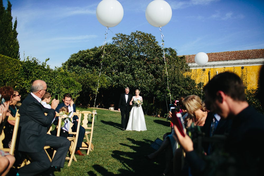 bride walking down the aisle in Quinta Santa Ana #bride #smallwedding #vineyard #balloons #portugalphotographer #quintasantana #vineyard #vineyardwedding #outdoorceremony