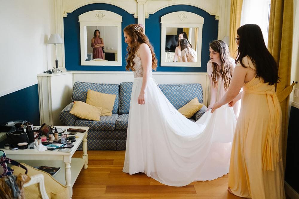 bridesmaids and friends helping bride before ceremony