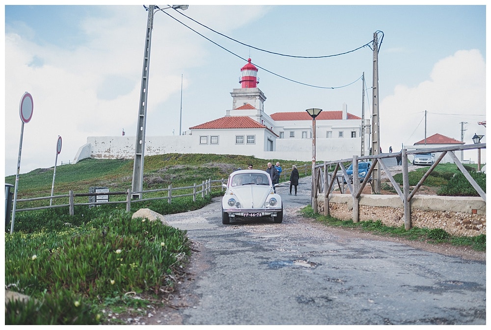 bride arriving in old fashioned beetle at cabo da Roca lighthouse 