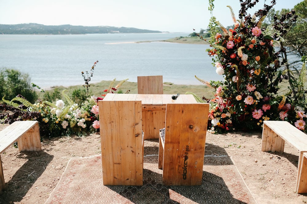 Ceremony wood table overlooking the lake in Obidos at Rio do Prado #platformceremony #lakewedding #lagoonwedding #riodoprado #Asymmetricalflowers #floralceremony #martaivensferraz #dsfloral