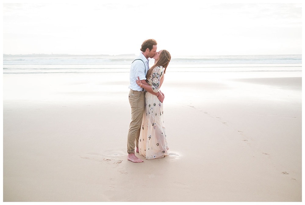 couple kissing at the sand beach for a surf wedding in Baleal peniche