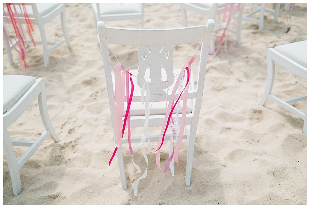 colorful wedding detail on a chair at the sand