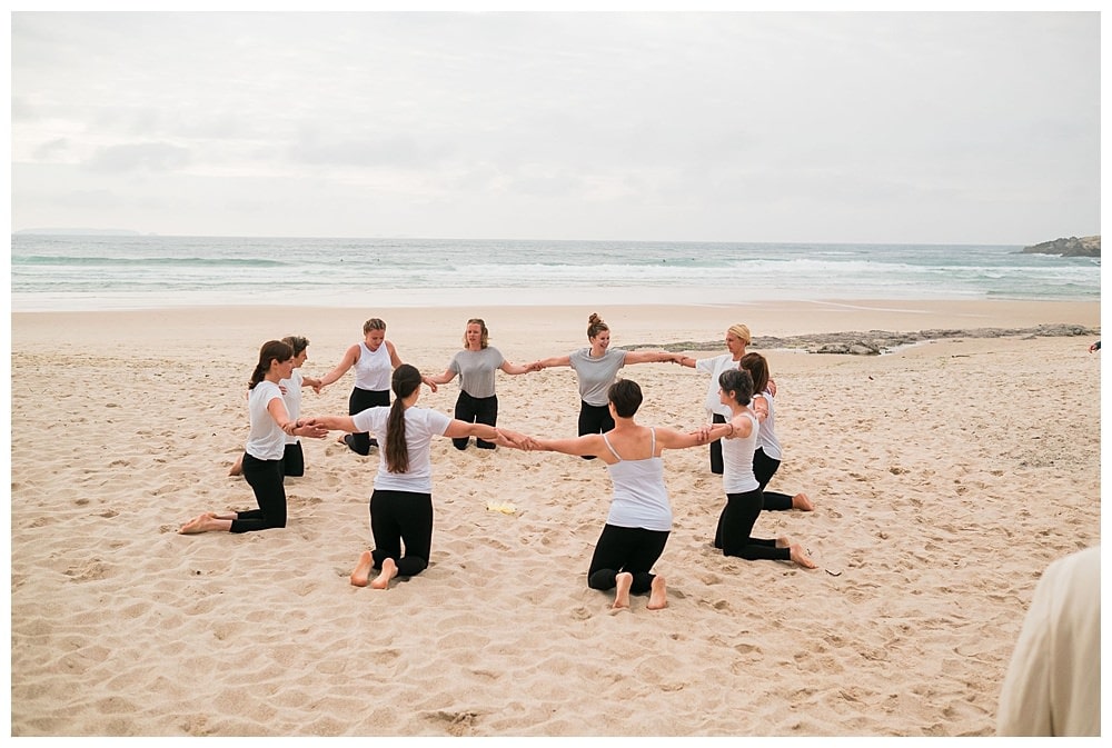 group of girls with bride yoga family at the sand beach #namaste #yogawedding #yogalife #beach #peniche #baleal #surf #beachwedding