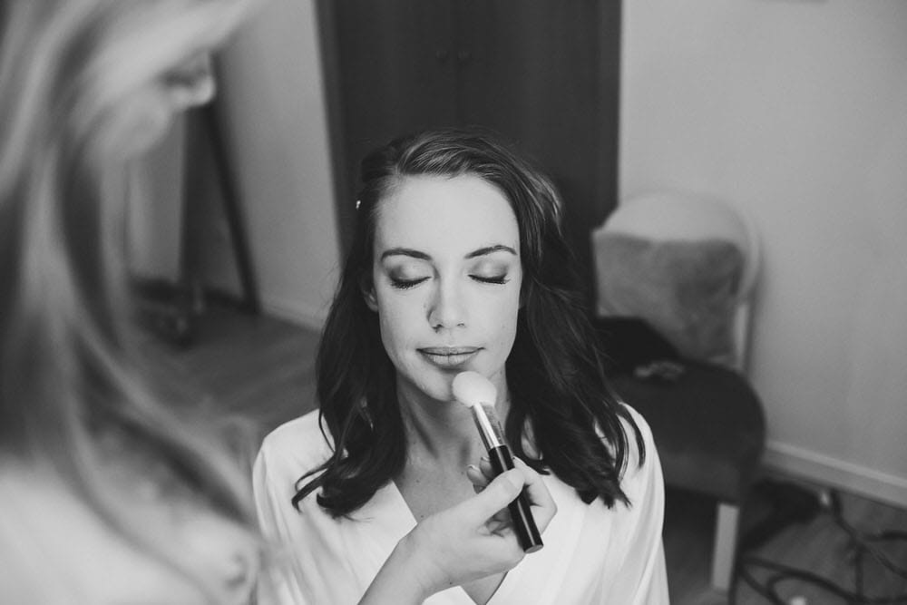 Relaxed bride, being pampered by her best friend with makeup before the ceremony