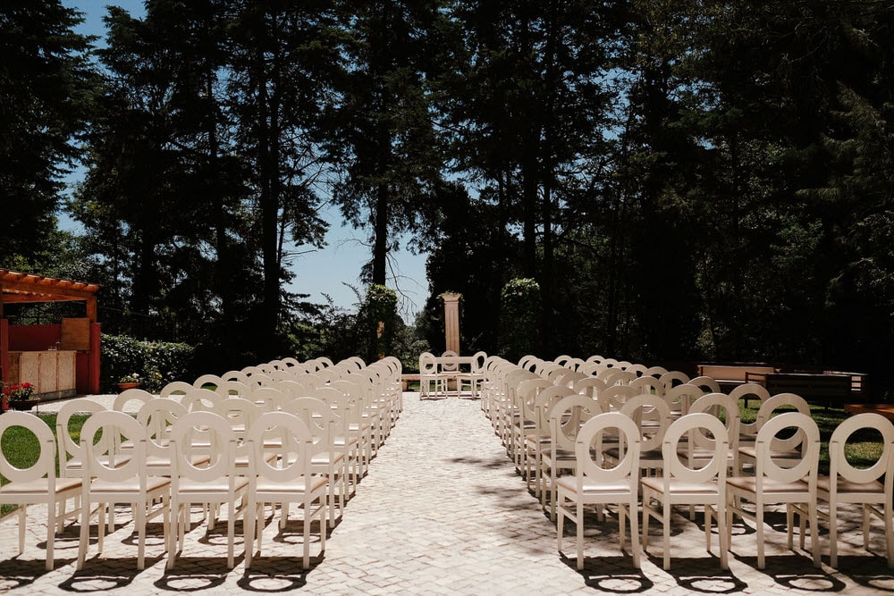 Setting up chairs at the wedding venue before the nuptial ceremony, with circular patterns and an aisle with columns at the quinta da Bichinha