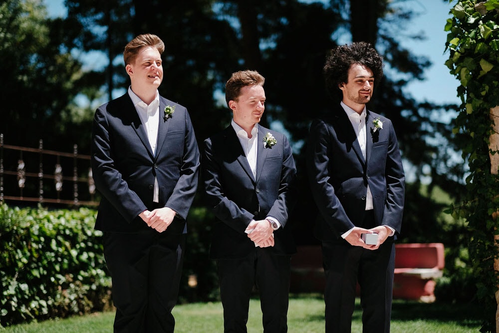 The smiling best man and groomsmen during the ceremony