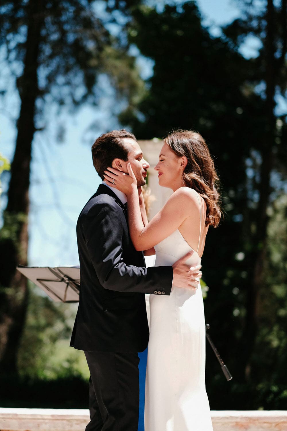 The couple shares their first kiss during the ceremony, with friends looking on and smiling