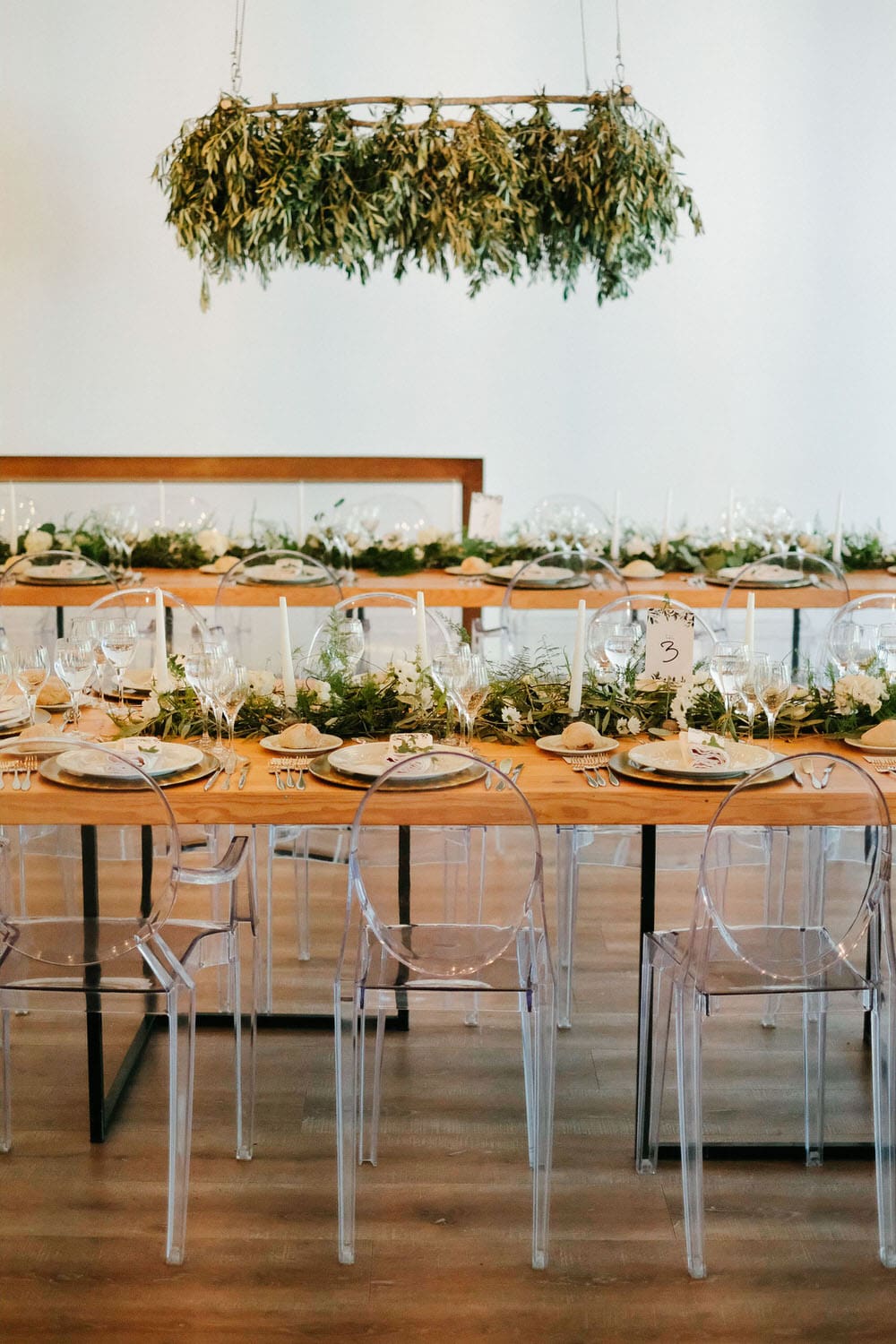 Quinta da Bichinha rustic destination wedding . Elegant wedding hall with symmetrically arranged tables and a vertical garden hanging over the tables in warm tones, complemented by the green of the plants