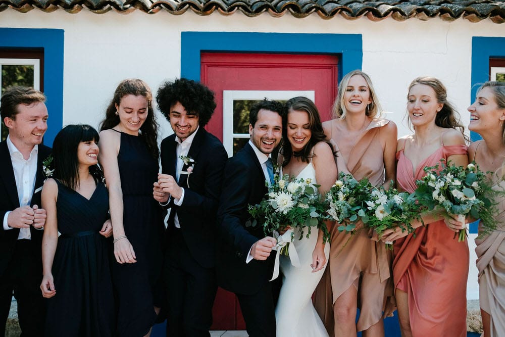 Joyful moments with the bride and groom's friends at the wedding party photo shoot in front of the traditional Portuguese facade at Quinta da Bichinha