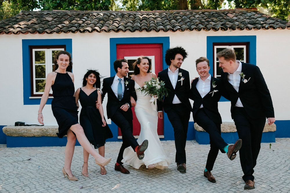Lighthearted moments with the bride and groom's friends at the wedding party photo shoot in front of the traditional Portuguese facade at Quinta da Bichinha