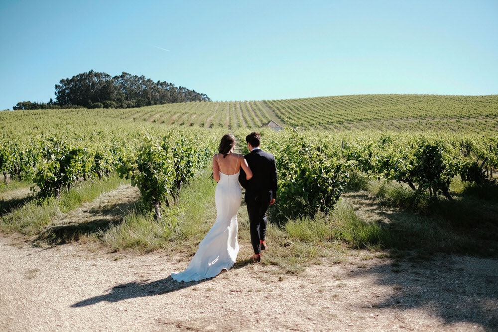 Quinta da Bichinha rustic destination wedding . The couple walks through the vineyards of the quinta da bichinha