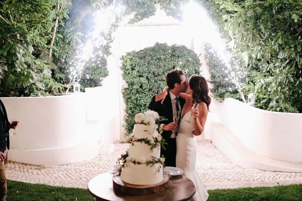 The couple celebrates in front of fireworks and with their wedding cake, toasting to all their guests
