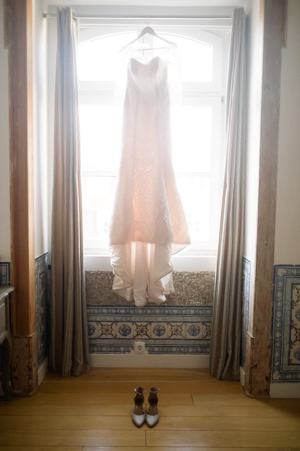 wedding dress hanging over Portuguese tiles at a pombalina windows