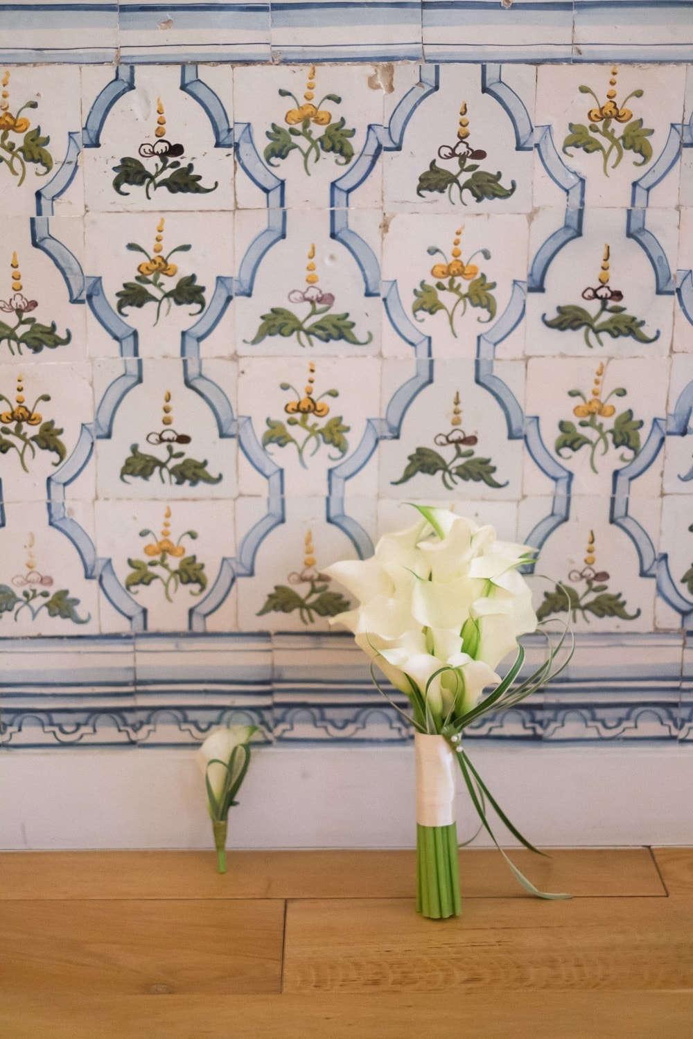 white bouquet and boutonniere over portuguese tiles on the wood floor of a house at the baixa in Lisbon