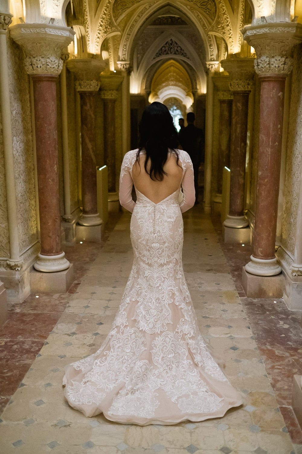 bride walking down with long tail wedding dress the columns corridor at the Monserrate Palace in Sintra