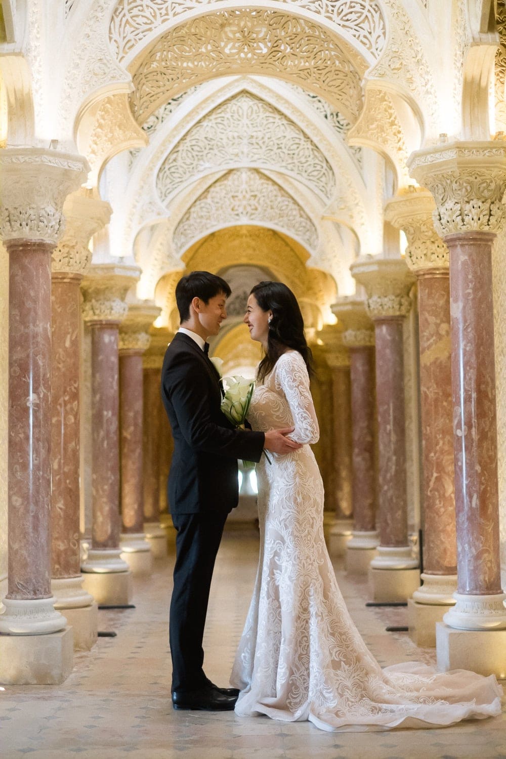 Asian American couple looking each other in love at the columns corridor in Monserrate palace in Sintra