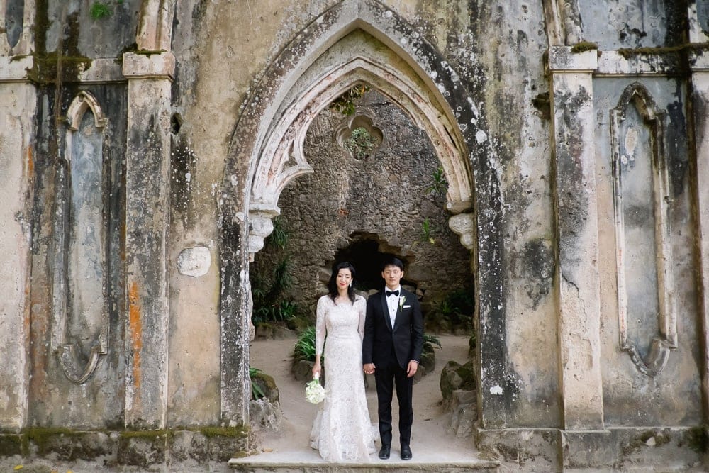american asian couple at the chapel ruins in the gardens of Mosnerrate palace in SIntra