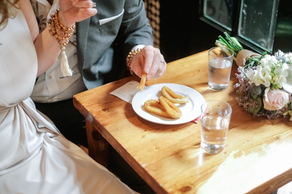 eating churros in jewish quarter in seville elopement photographer