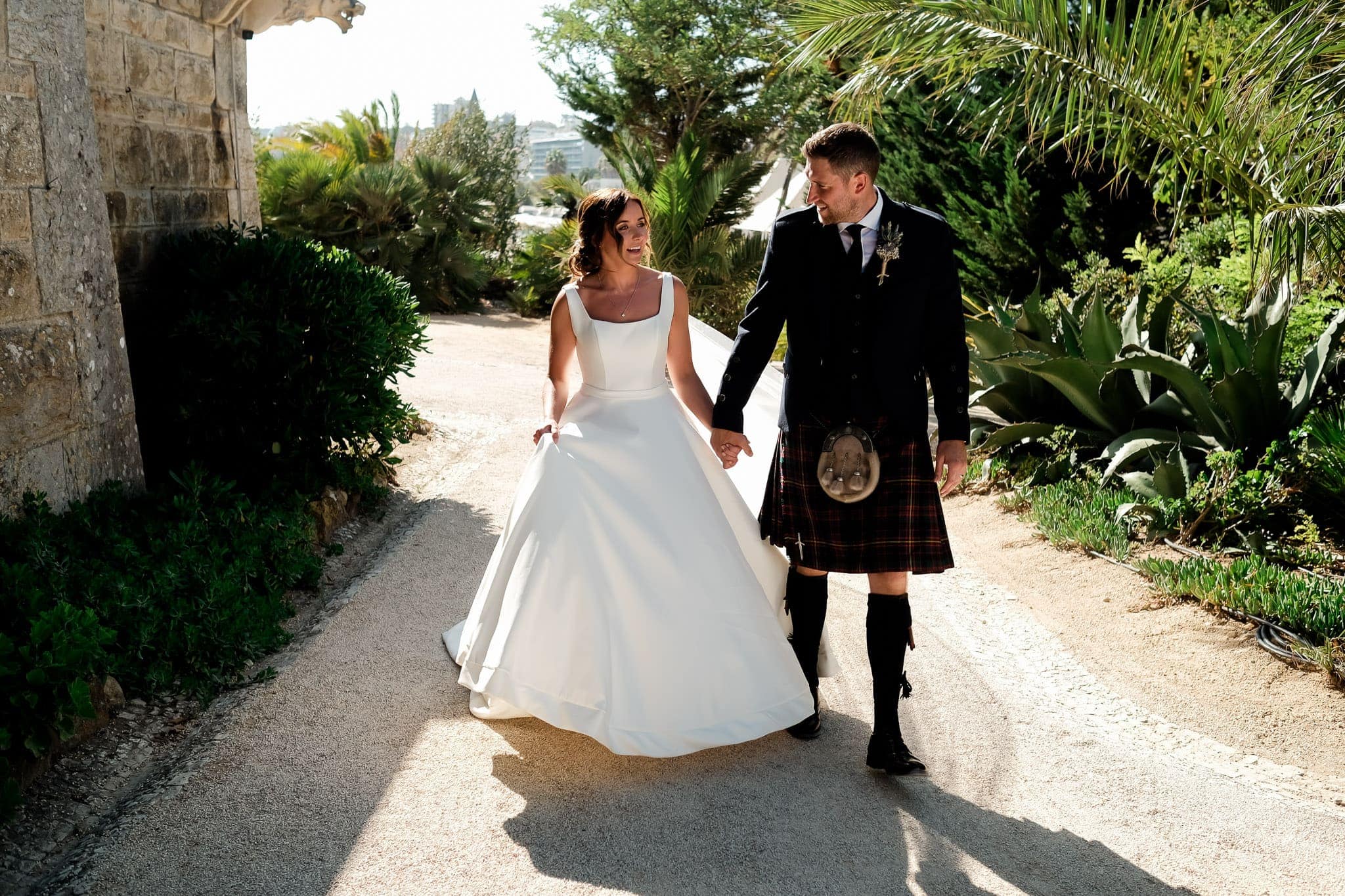 Scottish couple with groom dressing kilt walking by the walls of the forte da cruz wedding